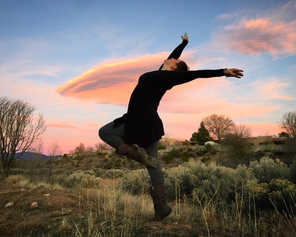 Kristin Lucero dancing outside in front on pink sky