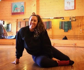 Kristin Lucero sitting on floor of dance studio, smiling