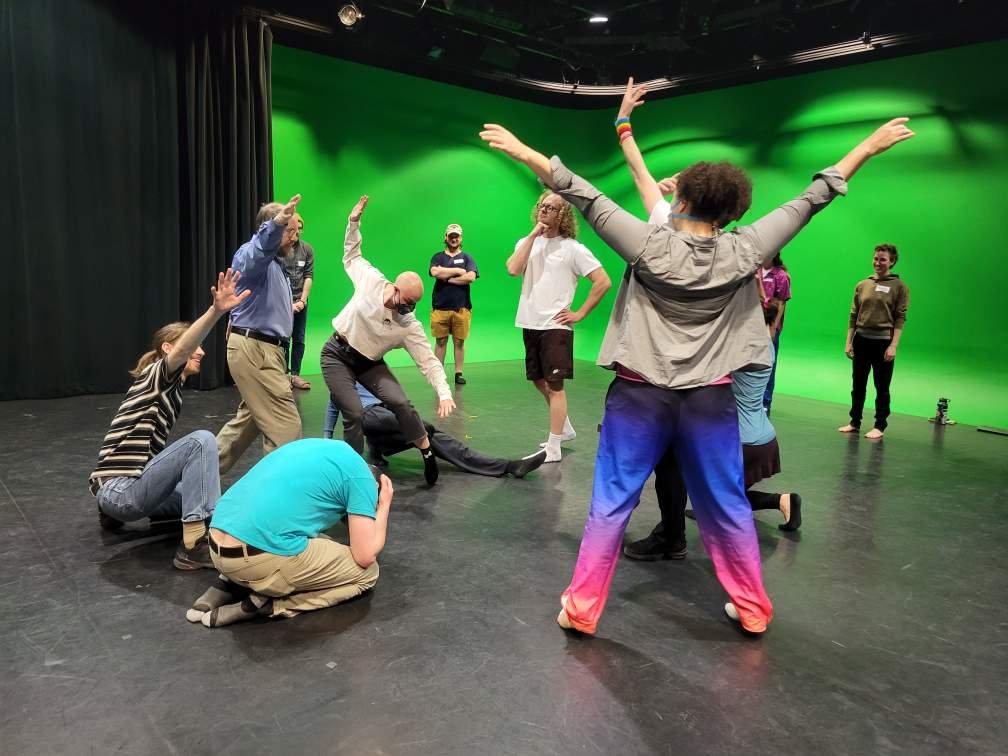 Group in poses in front of green screen
